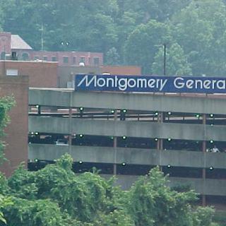 View of Montgomery General Hospital's parking structure amidst a lush green landscape.