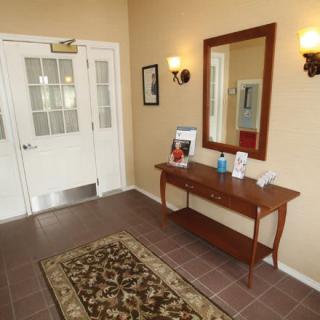 A well-decorated entrance lobby with a table, mirror, and carpet.