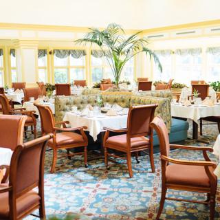 A bright and elegant restaurant dining area with neatly arranged tables and chairs.
