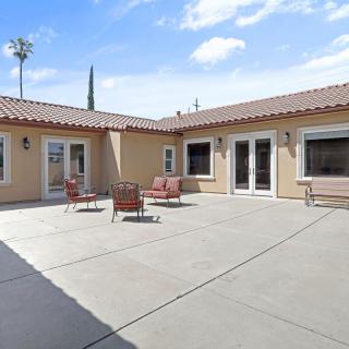 A sunny courtyard featuring outdoor furniture and a spacious patio area.