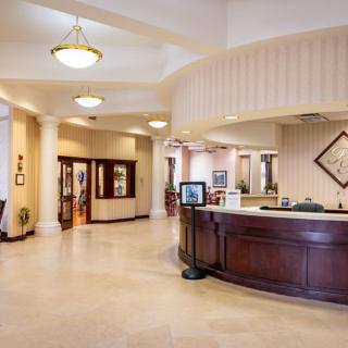 A modern and spacious hotel lobby with a reception desk and elegant lighting.