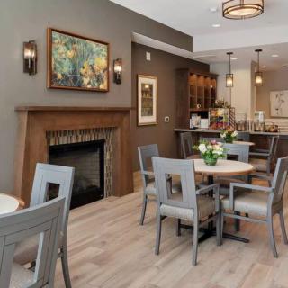 A cozy dining area with a fireplace, art on the walls, and modern furniture.