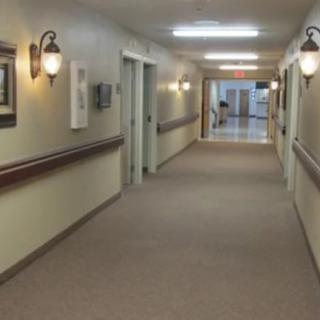 A well-lit indoor hallway with carpeted floors and doors on either side.