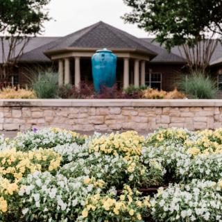 A beautifully landscaped garden with colorful flowers in front of an elegant building.