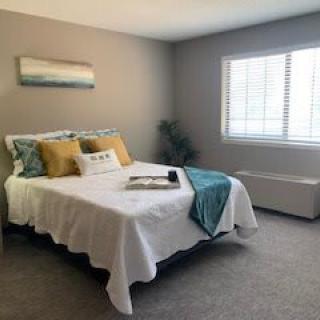A cozy and modern bedroom with a neatly made bed and minimalist decor.
