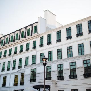A view of a modern white building with multiple windows and a streetlamp.