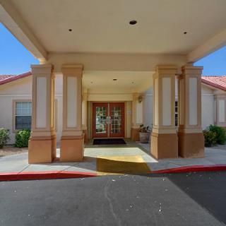 Entrance of a building with a covered walkway and columns.