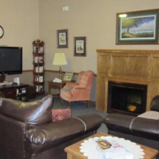 A cozy living room with a television, fireplace, and comfortable seating.