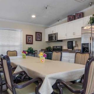 A spacious dining area featuring a large table and modern kitchen appliances.
