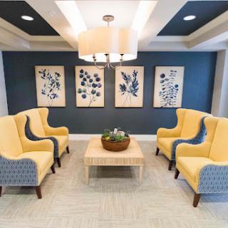 A cozy lounge area featuring modern yellow chairs and botanical artwork.