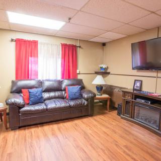 A cozy living room featuring a leather sofa, vibrant curtains, and an entertainment setup.