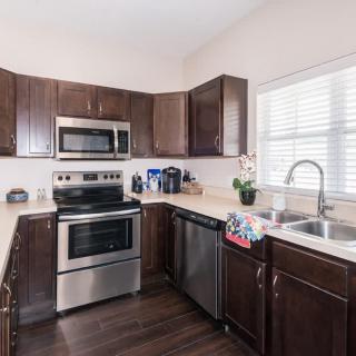 A modern kitchen with stainless steel appliances and dark wooden cabinets.