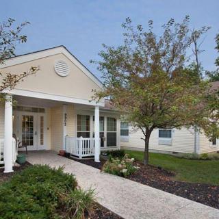 A quaint residential house with a front porch and landscaped yard.