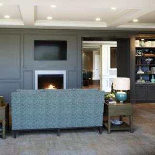 A modern living room with a fireplace, stylish sofa, and built-in shelves.