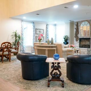 A cozy living room with stylish furniture, featuring a fireplace and decorative accents.