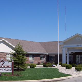 An exterior view of a brick building with a landscaped area and clear blue sky.