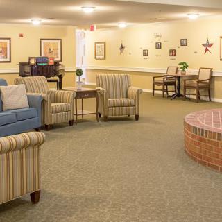A cozy seating area with comfortable chairs and a sofa in a warmly lit lobby.