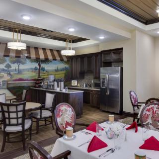 A beautifully arranged dining area with elegant furniture and a modern kitchen backdrop.