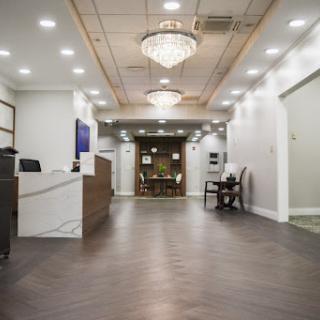 A modern hotel lobby featuring elegant chandeliers and stylish flooring.