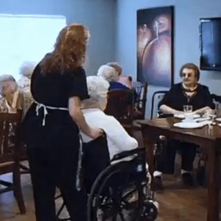 A caregiver assists elderly residents in a nursing home setting.