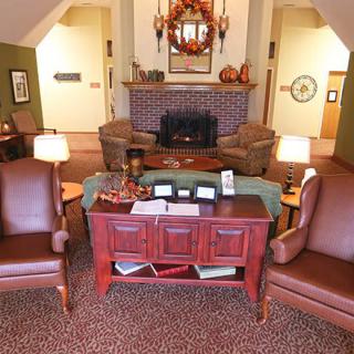 A warm and cozy living room with autumn-themed decorations and a central fireplace.