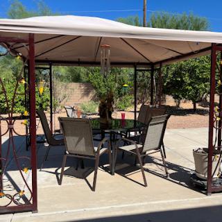 A cozy outdoor gazebo set up for relaxation with comfortable furniture.