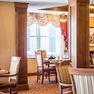 A warmly decorated dining area with wooden furniture and elegant window treatments.