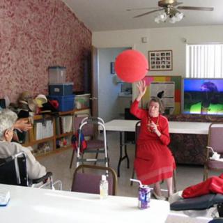 A group of seniors engaging in a ball game at an elderly care facility.