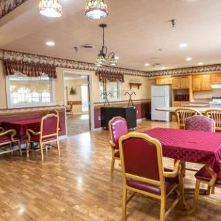 A warm and inviting dining area featuring wooden furniture and a well-equipped kitchen.