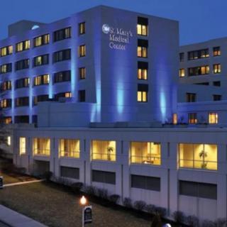 A well-lit hospital building glowing against the night sky.