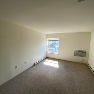 A bright and empty room with a window allowing natural light, ready for new furnishings.