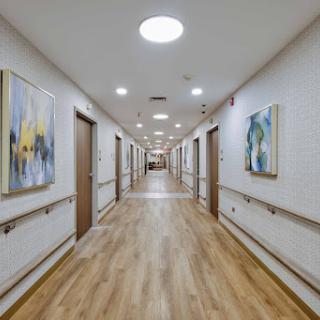 A well-lit hallway featuring artwork on the walls, showcasing modern interior design.