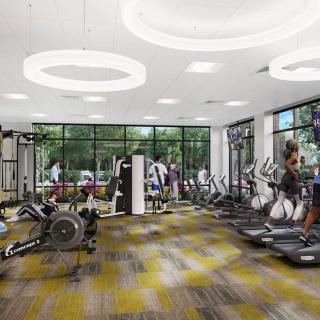 A modern gym with various exercise equipment and people working out.