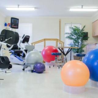 A rehabilitation room equipped with various exercise equipment and therapy balls.
