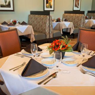 An elegantly set dining table in a modern restaurant, featuring tasteful decor and floral arrangements.