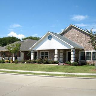 A suburban brick house with a well-maintained front yard.