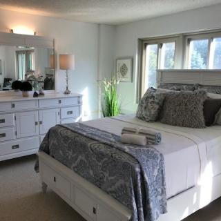 A well-lit bedroom with elegant decor and a neatly made bed.