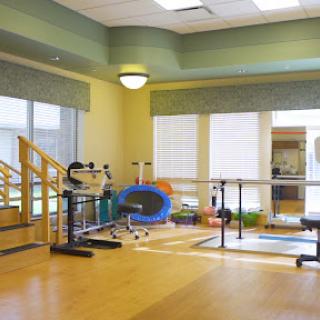 A well-lit physical therapy room equipped with various exercise tools for rehabilitation.