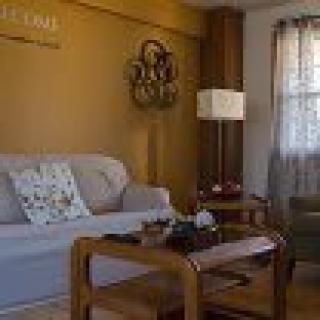 A cozy living room with a beige sofa, wooden coffee table, and decorative items.