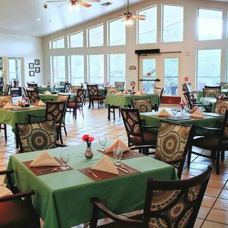 A well-lit restaurant dining area with neatly arranged tables and chairs.