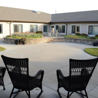 A serene courtyard with two chairs and a landscaped view.