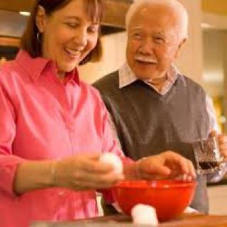 A man and a woman enjoying cooking together in the kitchen.