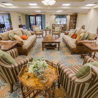 A well-furnished living room with multiple sofas, chairs, and coffee tables arranged in a cozy setting.