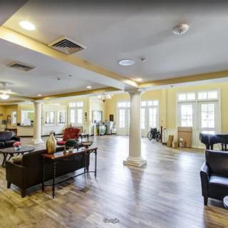 A spacious lobby with seating areas, large windows, and hardwood flooring.