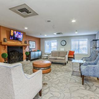 A cozy living room with comfortable seating, a fireplace, and a television.