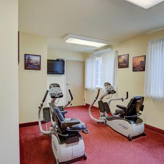 A small workout area with stationary bikes and a television.