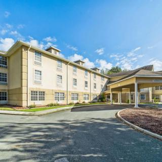 A hotel building with a welcoming entrance under a bright blue sky.