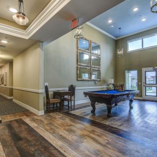 A modern interior space featuring a pool table and elegant lighting.