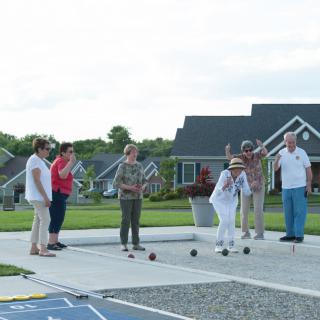 A group of seniors playing bocce ball in a community setting.