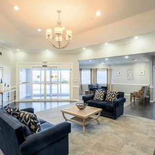 A modern living room with blue sofas and a chandelier.